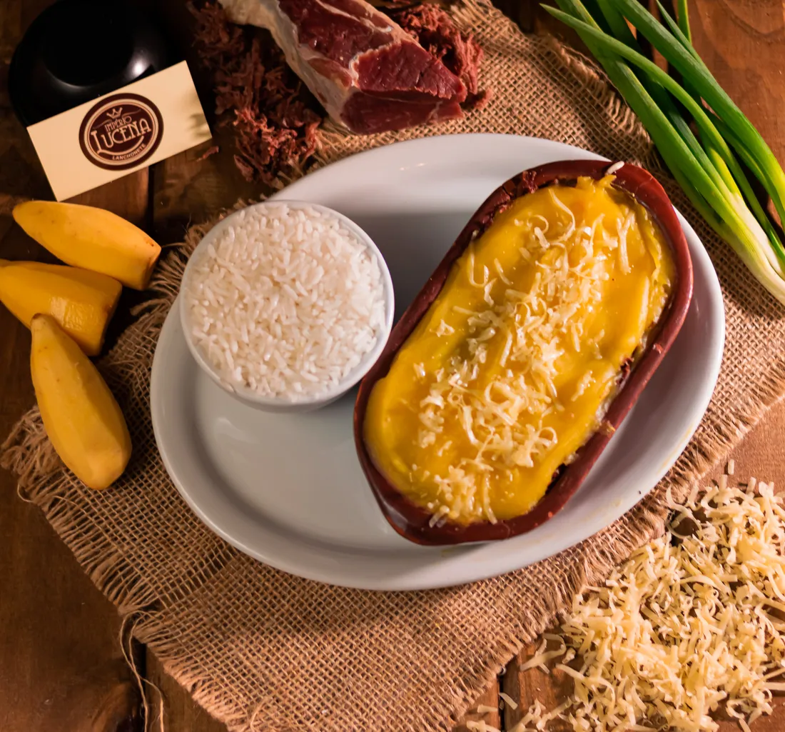 Escondidinho de carne-seca gratinado servido com arroz branco e mandioca